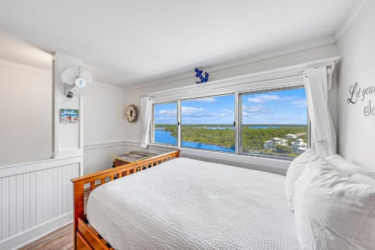 Habitación con cama doble y vistas panorámicas al lago en el condo Pinnacle Port, Panama City Beach