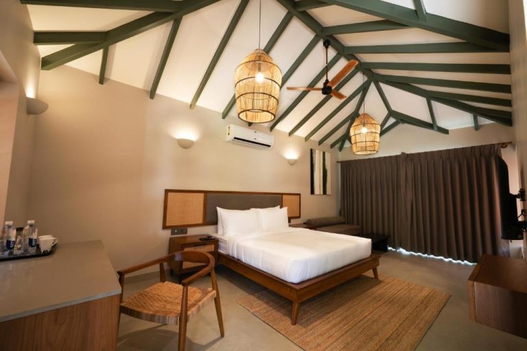 Habitación doble con techo de vigas de madera y lámparas de mimbre en el hotel SinQ Anvaya