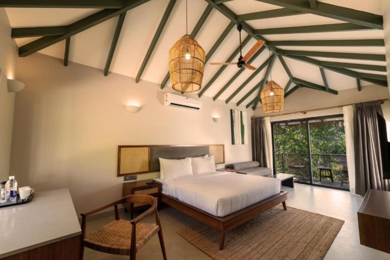 Habitación doble con techo de vigas verdes y lámparas de ratán en el resort SinQ Anvaya