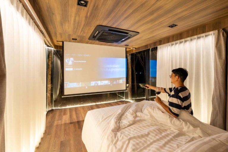 Habitación con cama doble y pantalla de proyector para cine en casa en Timber Society Boutique Hideaway