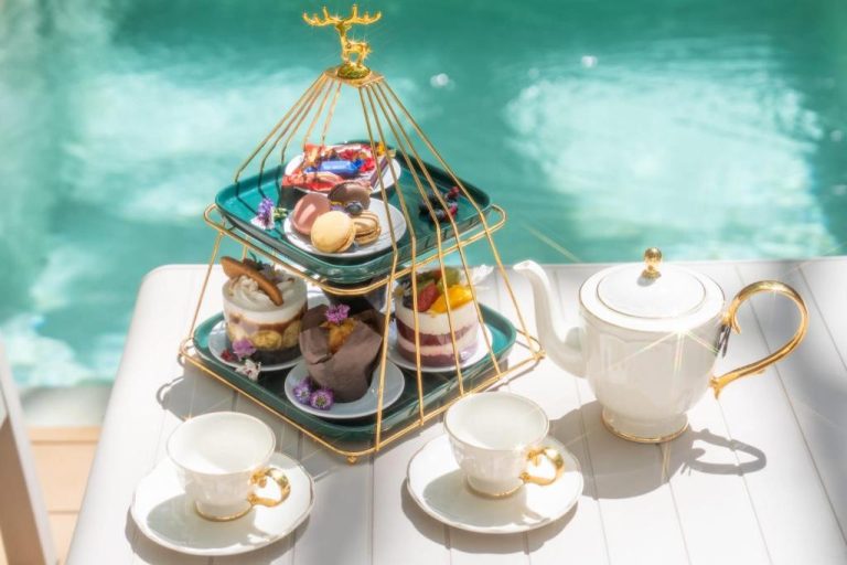 Servicio de afternoon tea con pastelería y tetera junto a la piscina del Timber Society Boutique Hideaway