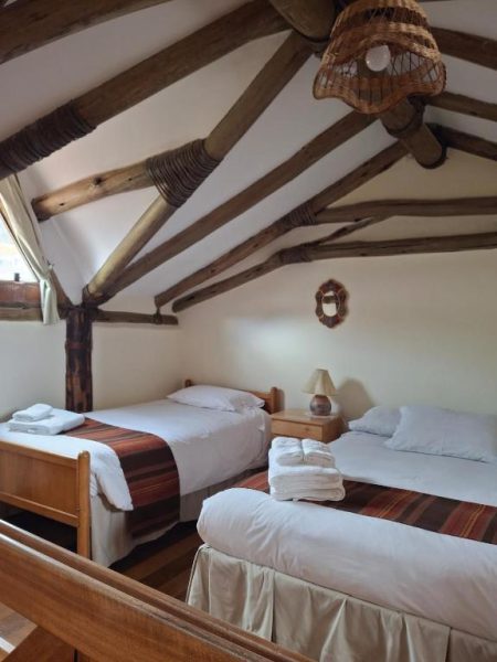 Habitación doble rústica con vigas de madera y dos camas en Casona La Recoleta