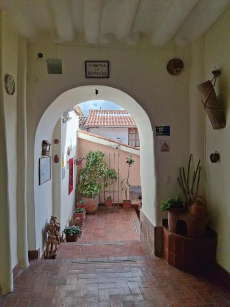 Patio interior con arco de entrada y plantas decorativas de la Casona La Recoleta