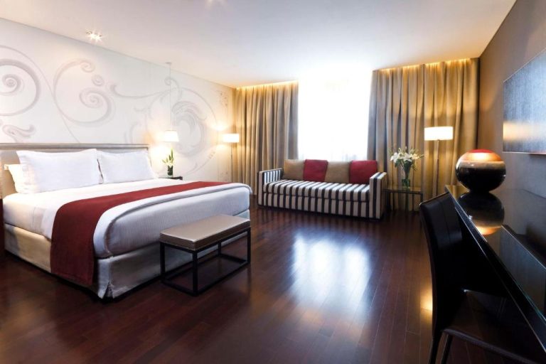 Habitación superior con cama king size y suelo de madera en el NH Buenos Aires Tango