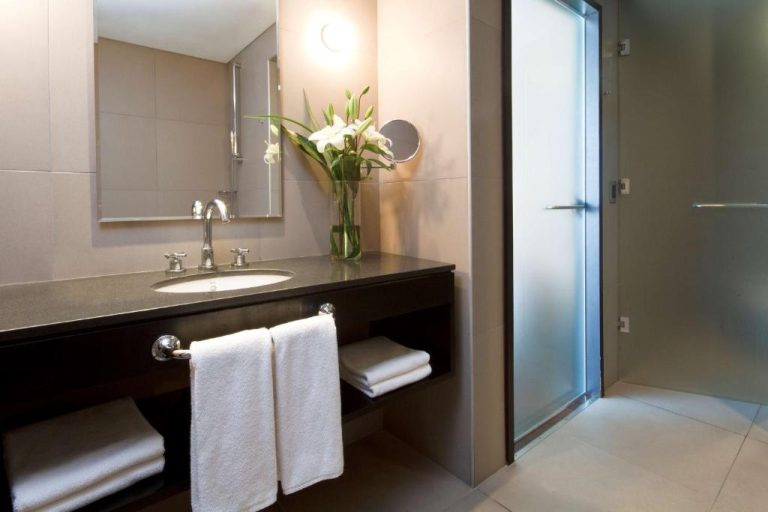 Baño moderno con ducha de cristal y lavabo de mármol en el NH Buenos Aires Tango
