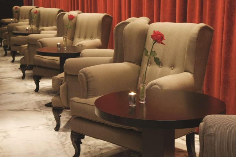 Elegante lounge bar con sillones tapizados, rosas rojas y velas del NH Buenos Aires Tango
