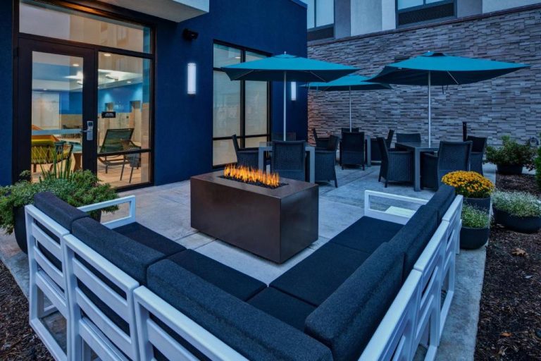 Terraza exterior con chimenea y sofás del Hampton Inn & Suites Indianapolis South Greenwood