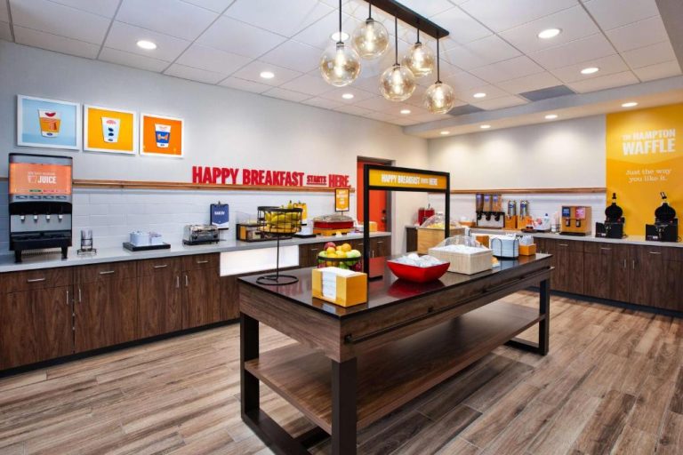 Zona de desayuno buffet gratuito con waffles y zumos en Hampton Inn & Suites Indianapolis South Greenwood
