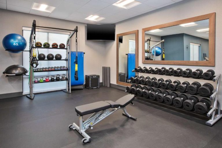 Gimnasio equipado con mancuernas, mesas de ejercicio y pelotas medicinales en Hampton Inn Indianapolis South Greenwood