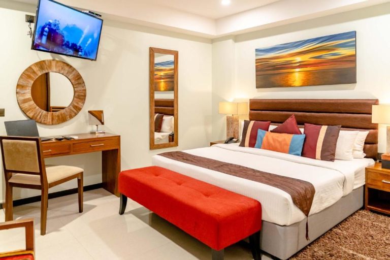Habitación deluxe con cama matrimonial, escritorio y TV en The Somerset Hotel