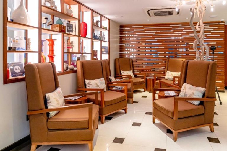 Sala de espera del The Somerset Hotel con cómodas butacas de madera y decoración moderna