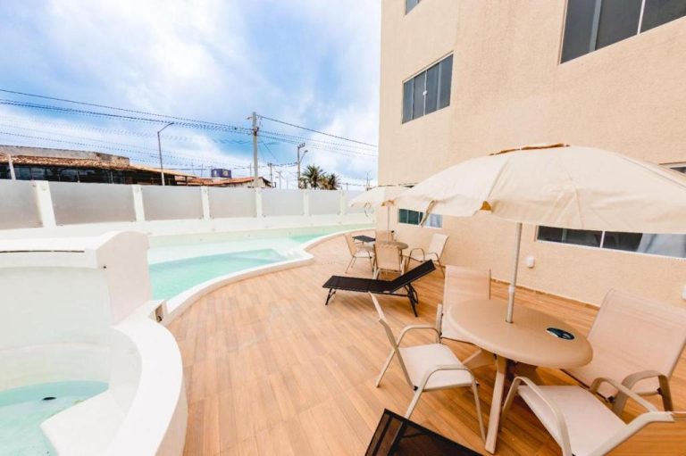 Terraza con piscina exterior, tumbonas y sombrillas del hotel Paraíso das Dunas