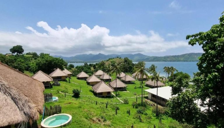 Bungalows con techo de paja y vistas al mar del resort Bleu Mathis Gili Asahan rodeados de palmeras