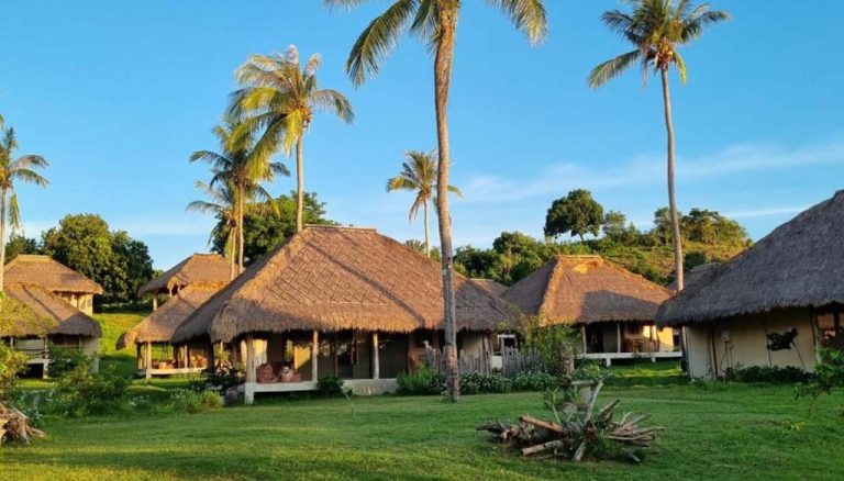 Bungalows con techo de paja rodeados de palmeras tropicales en Bleu Mathis Gili Asahan