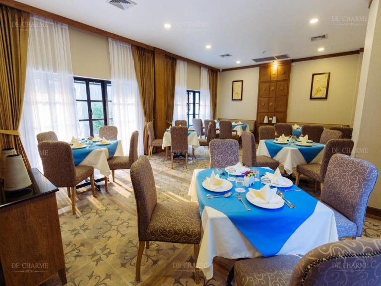 Salón restaurante elegante con mesas azules y sillas tapizadas del Decharme Hotel