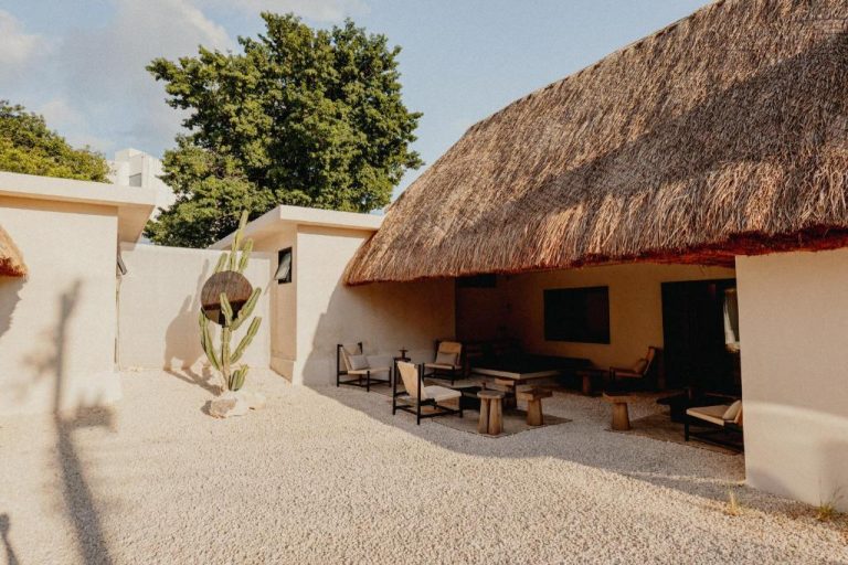 Terraza exterior con palapa de palma y zona lounge del Ixum Casa Hotel Boutique en México