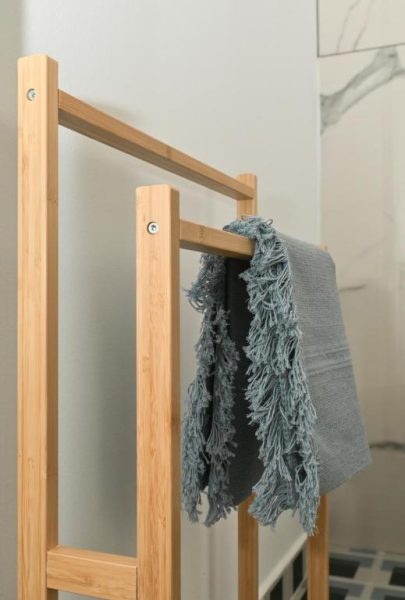 Toallero de bambú con toallas de flecos azules en el baño de MILIN DOM Premium Apartments