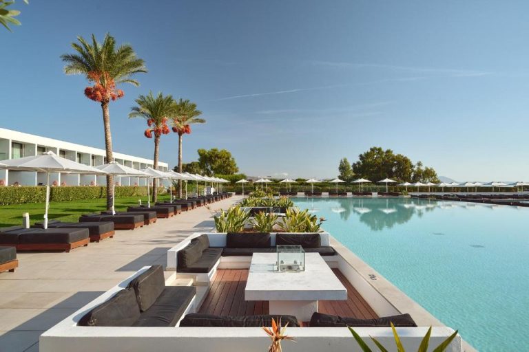 Piscina exterior con tumbonas y palmeras del Gennadi Grand Resort Premium All Inclusive en Rodas