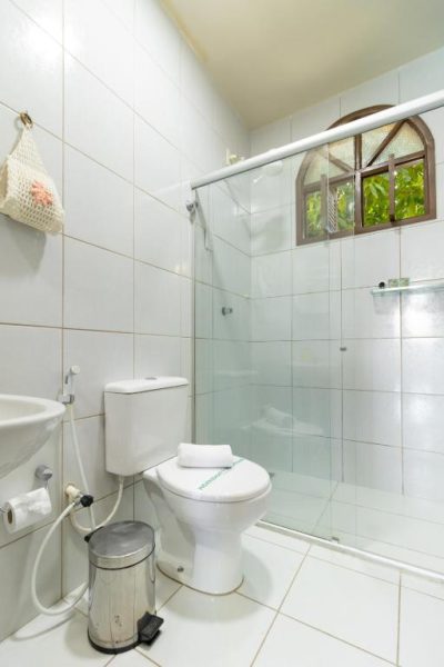 Baño privado con ducha de cristal y ventana con vista al jardín en Pousada da Terra