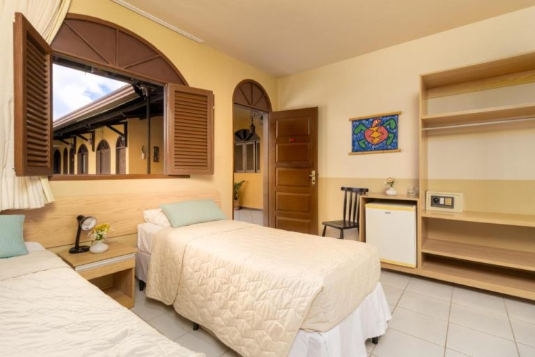 Habitación doble con dos camas y ventana de madera en Pousada da Terra