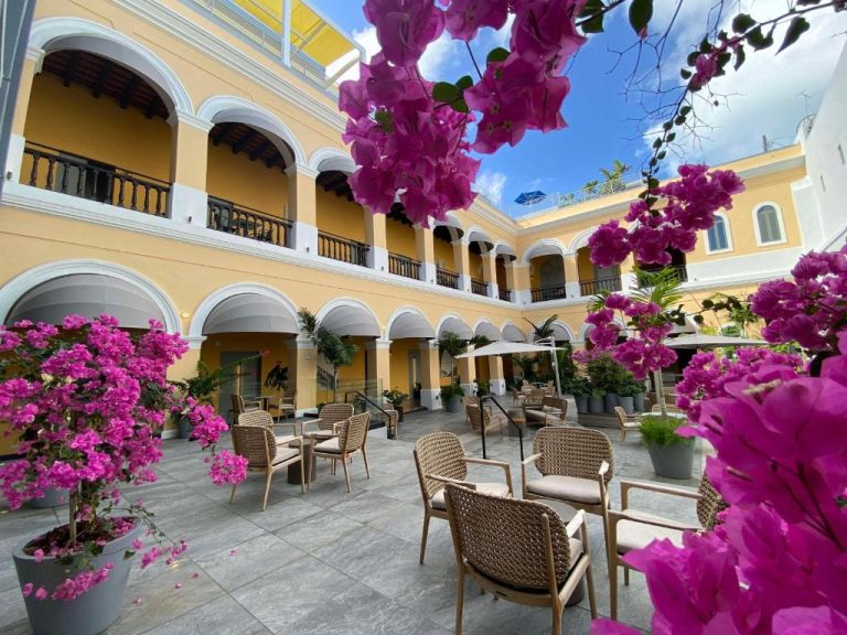 Patio interior con buganvillas rosas y terraza del Palacio Provincial San Juan Curio Collection by Hilton