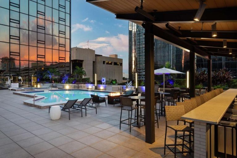 Piscina exterior con terraza y bar al aire libre del Hilton Tampa Downtown al atardecer