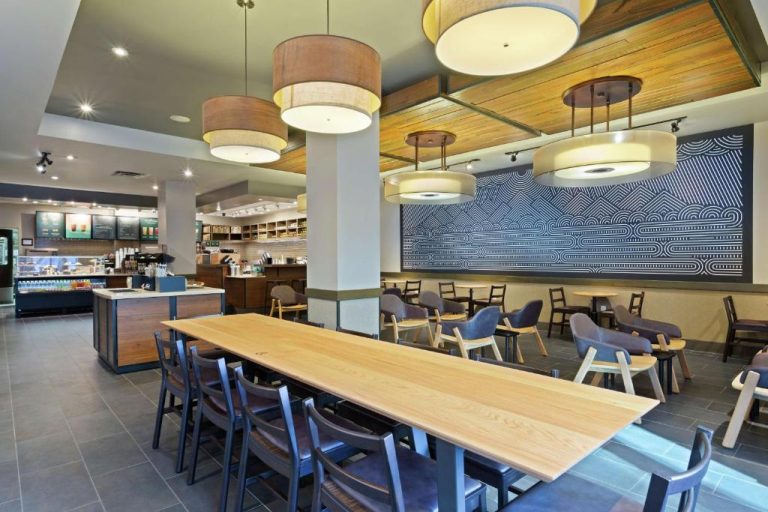 Cafetería Starbucks con mesas de madera y zona de descanso en el Hilton Tampa Downtown