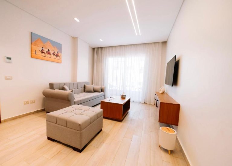 Salón moderno con sofá, televisión y decoración egipcia en Zones Residence Maadi El Cairo