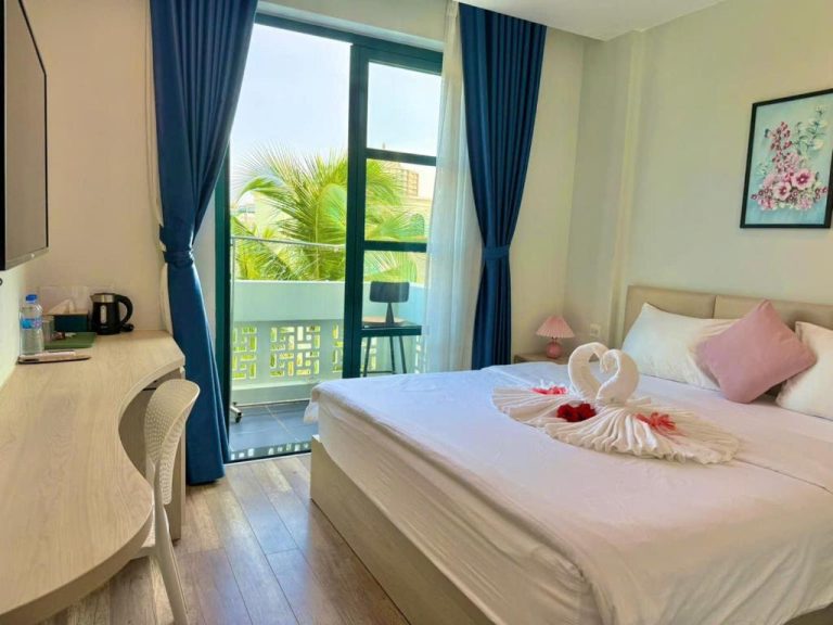 Habitación doble con balcón y vistas a palmeras en Minh Anh Hotel, decoración romántica con cisnes