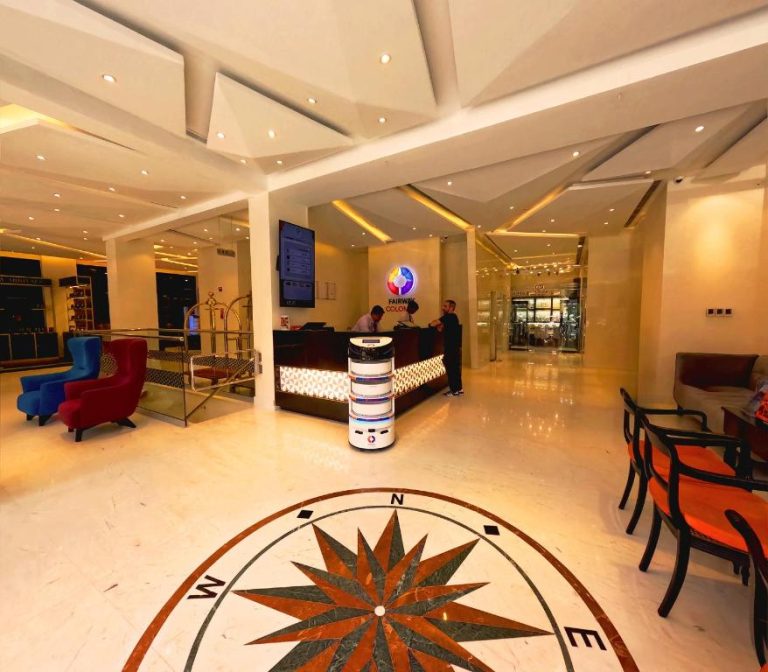 Recepción del Fairway Colombo con robot tecnológico en el lobby y suelo con rosa de los vientos