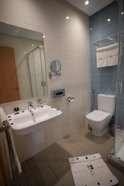 Baño moderno con ducha, lavabo y accesorios de cortesía del Hotel Zephyr Agadir