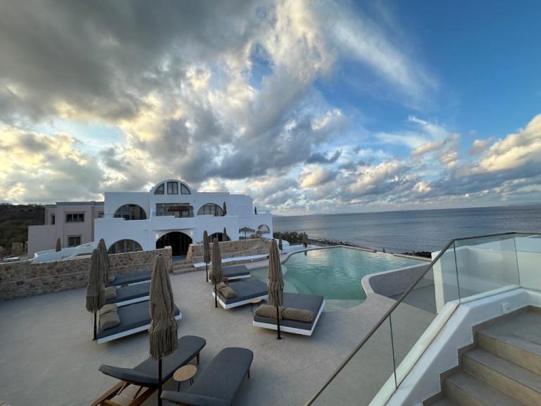 Piscina infinita con tumbonas y sombrillas del Hotel Aelia Thalassa con vistas al mar Egeo