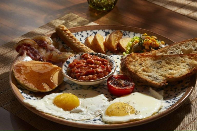 Desayuno completo tipo inglés con huevos, bacon, tostadas y judías en Radha House Siolim Boutique Hotel