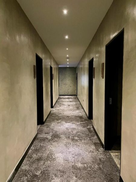 Pasillo interior elegante con moqueta y puertas negras del BaBa Boutique House Langkawi