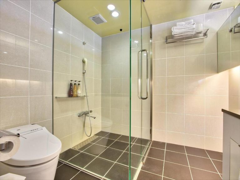 Baño moderno con ducha de cristal y aseo japonés en el hotel Palace In Moon Beach
