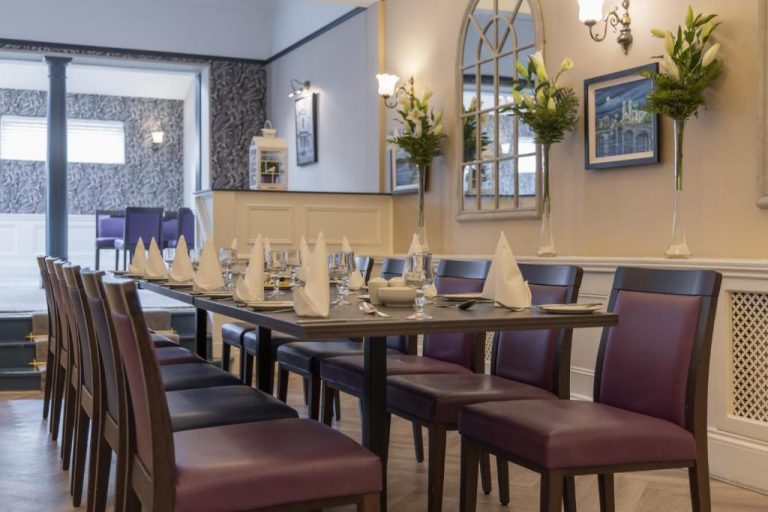 Elegante salón comedor privado con mesas largas y sillas tapizadas del Shamrock Lodge Hotel