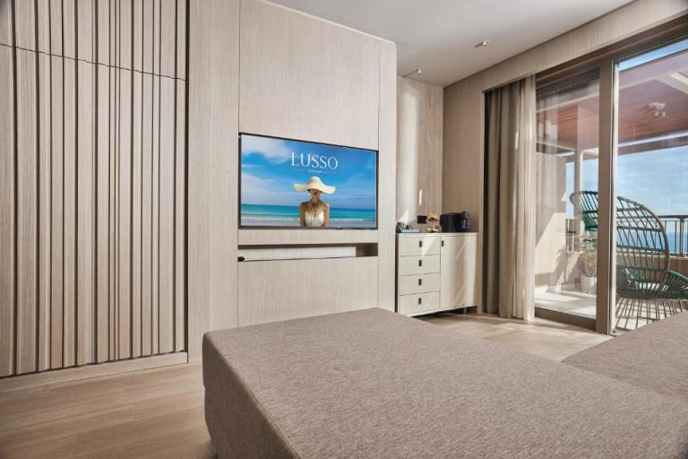 Habitación de lujo con televisor y terraza con vistas al mar en el hotel Lusso Sorgun