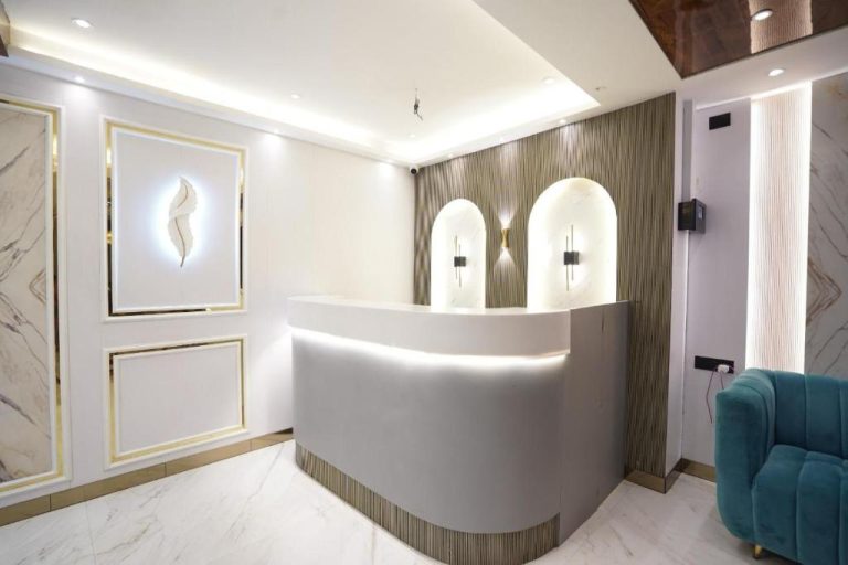 Recepción moderna y elegante del Hotel Lancaster con mostrador blanco y decoración en mármol dorado