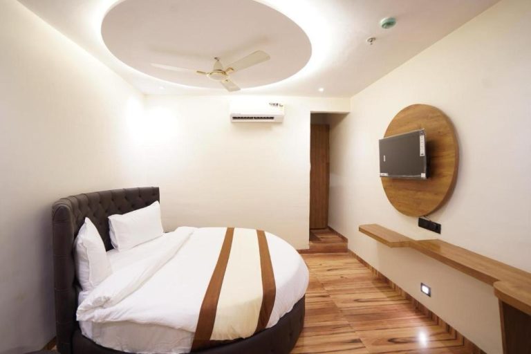 Habitación doble con cama redonda, TV y techo circular iluminado en Hotel Lancaster