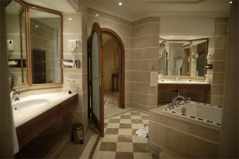 Lujoso baño con bañera de hidromasaje y detalles de rosas en Hasdrubal Prestige Thalassa Djerba