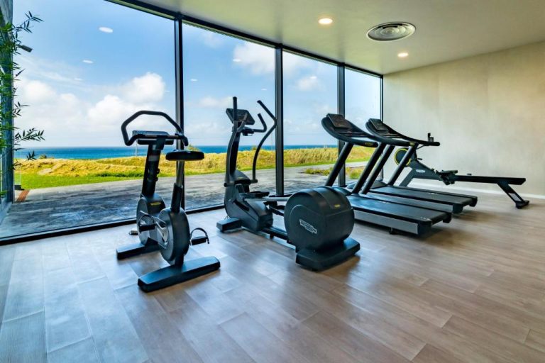 Gimnasio con equipamiento cardiovascular y vistas panorámicas al mar en Hotel Verde Mar & SPA