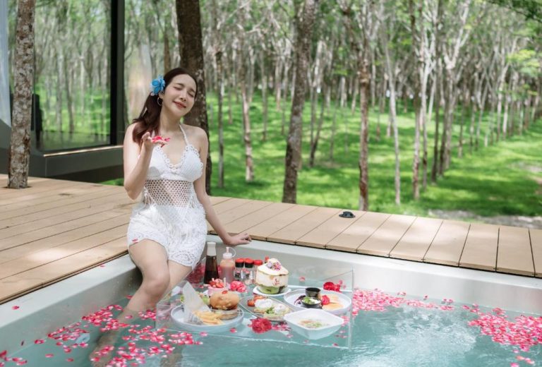 Mujer disfrutando del desayuno flotante en la piscina privada rodeada de naturaleza en Timber Society Boutique Hideaway
