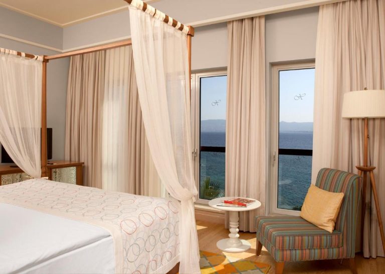 Habitación con cama de dosel y vistas al mar en Xanadu Island Hotel
