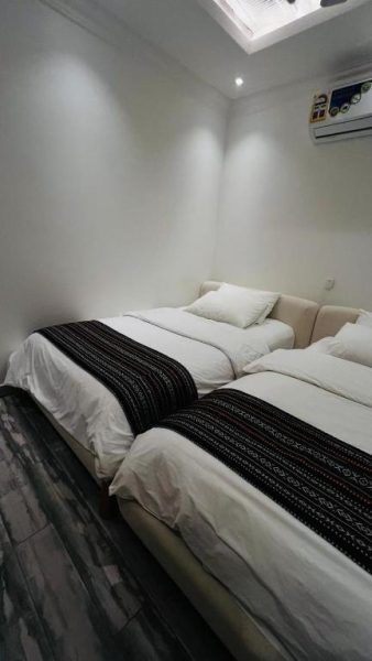 Habitación doble con dos camas y decoración en blanco y negro en Wadi Al Arbeieen Resort