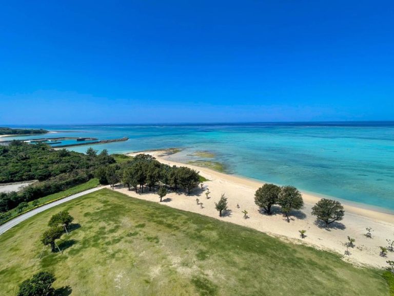 Vista aérea de la playa de arena blanca y aguas turquesas del Ryukyu Hotel & Resort Nashiro Beach en Okinawa