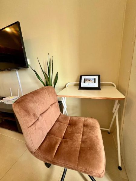Escritorio de trabajo con tablet y silla ergonómica en Cozy Studio Cebu IT Park