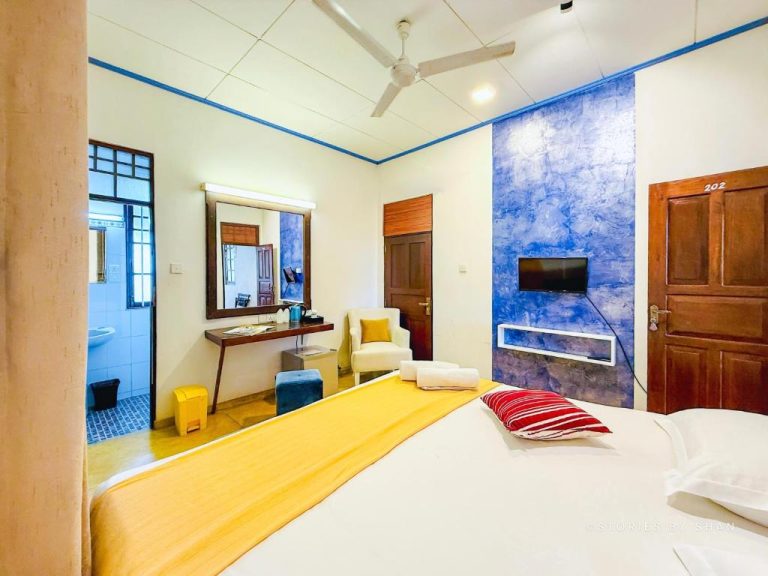Habitación doble con cama king, pared azul decorativa y TV en el Hotel Dorset