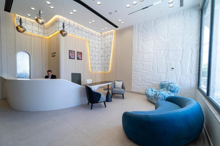 Recepción moderna del Hill Top Hotel con sofás azules y diseño elegante en el lobby principal