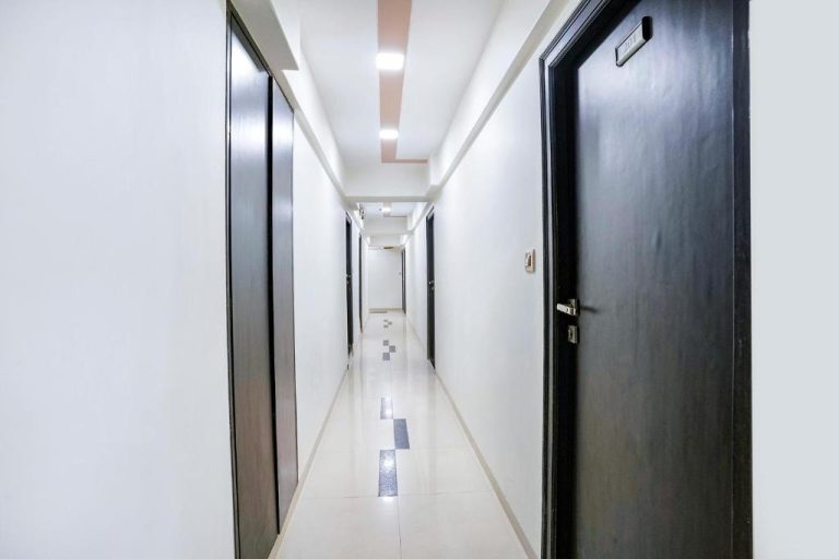 Pasillo interior iluminado con puertas de habitaciones en FabHotel Kamran Residency cerca de LBS Marg