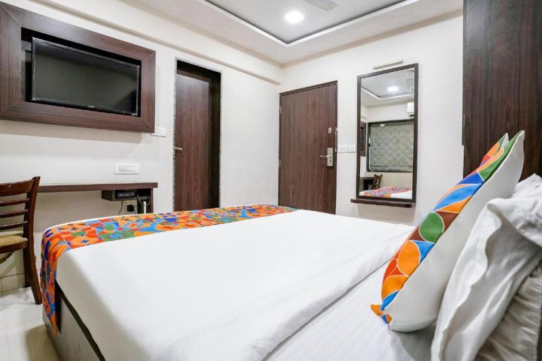 Habitación doble con cama matrimonial, TV de pantalla plana y espejo en FabHotel Kamran Residency